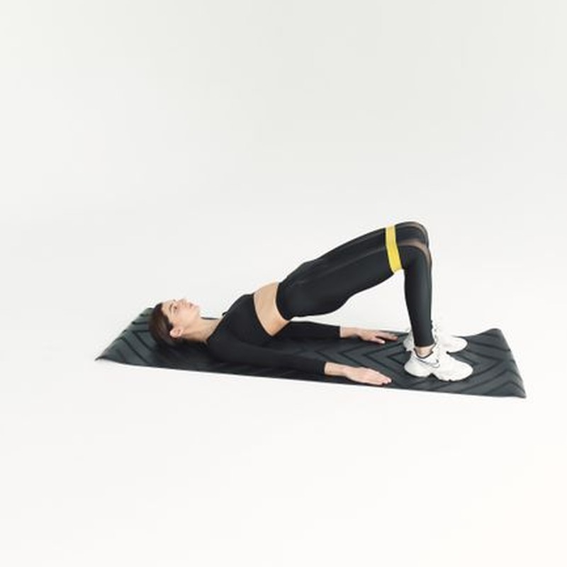 Person performing glute bridge exercise with proper form