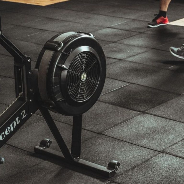 A gym scene featuring fitness equipment and active people exercising indoors.