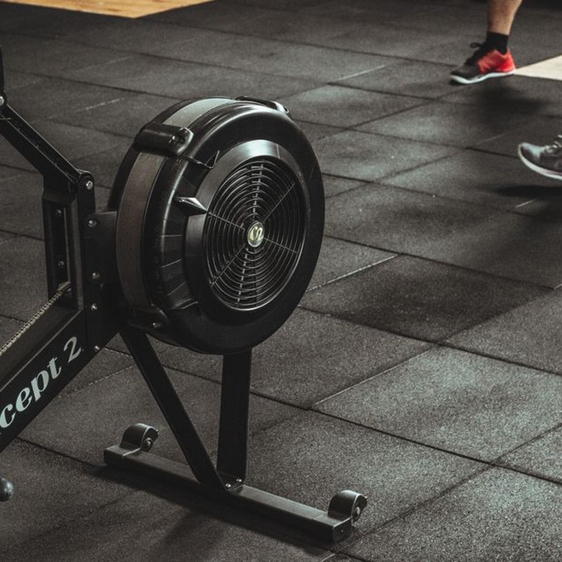 A gym scene featuring fitness equipment and active people exercising indoors.