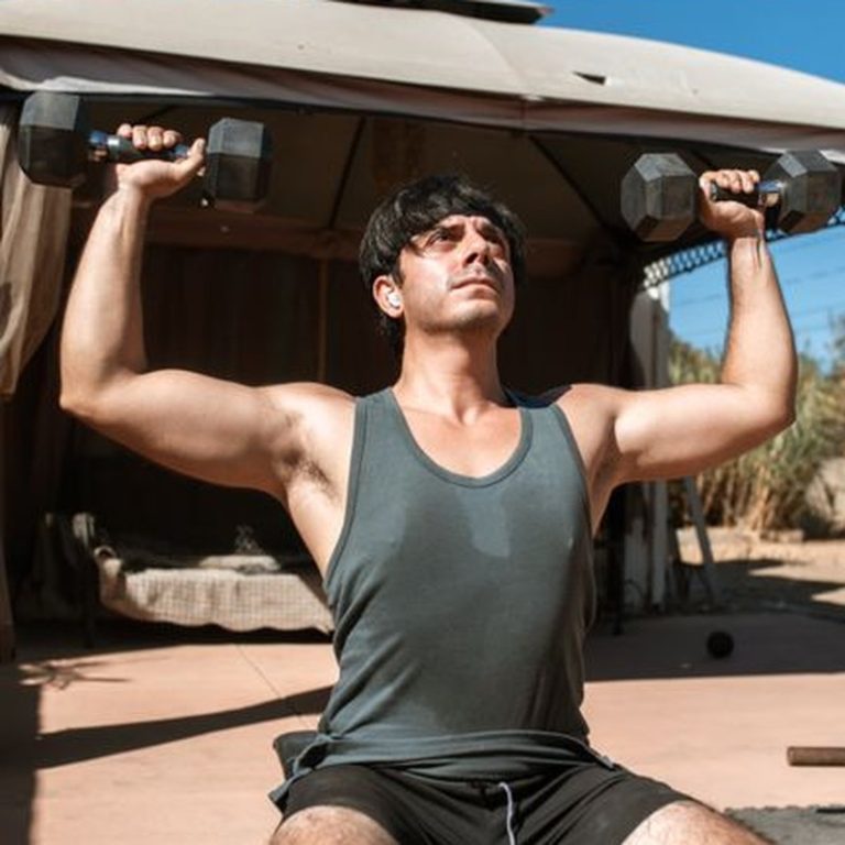 Adult man doing strength training with dumbbells outdoors on a sunny day for fitness.