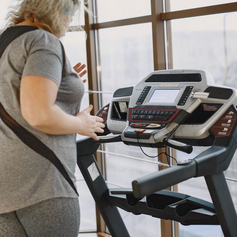 Woman exercising on treadmill in gym promoting healthy lifestyle and fitness.