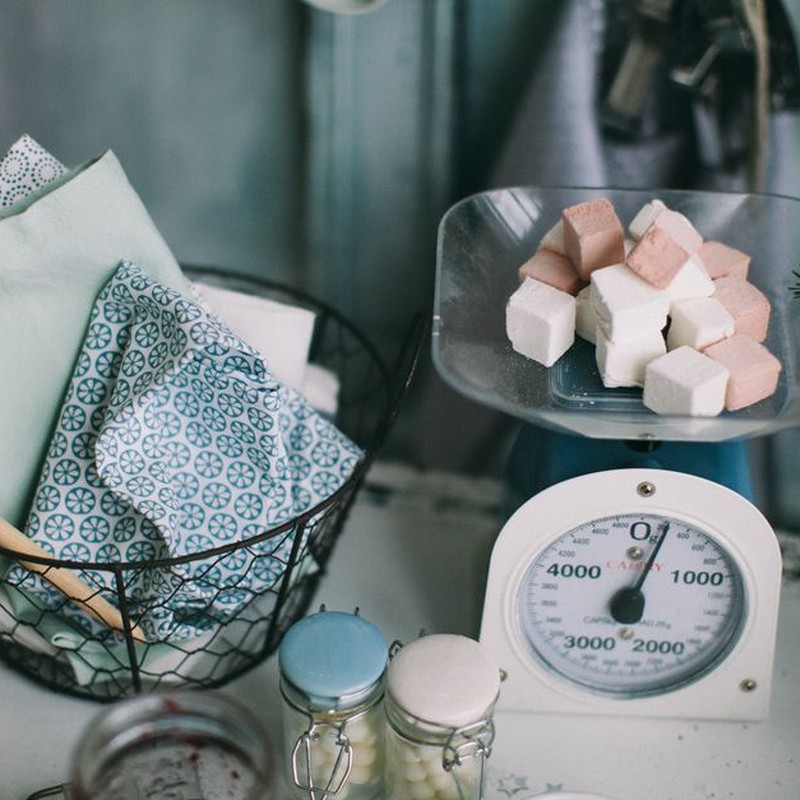 A charming kitchen setup showcasing baking essentials and sugar cubes on a scale.