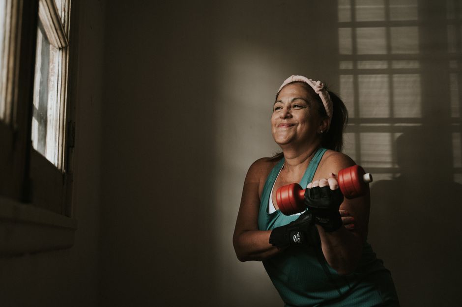 Busy adult training at home with dumbbells