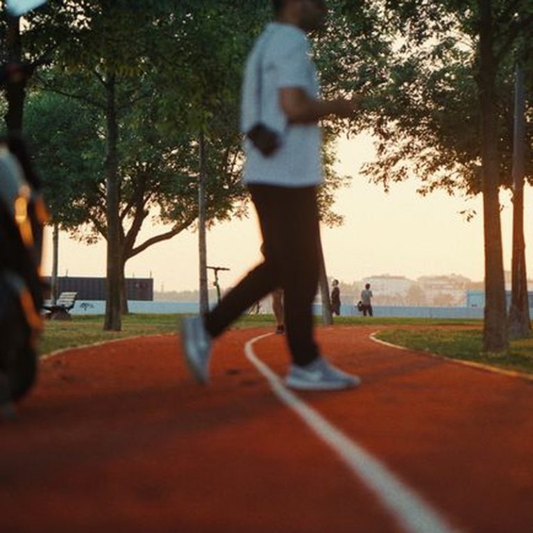 A blurred figure walking on a park track in Istanbul, capturing the serene sunset ambiance.