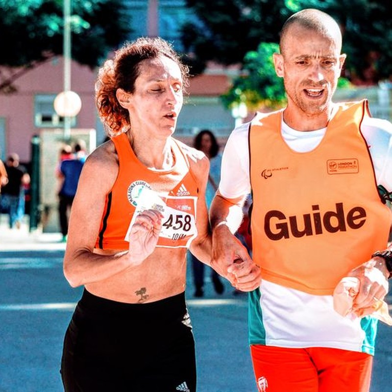 Two runners, a man and a woman, in a marathon with a guide through city streets.