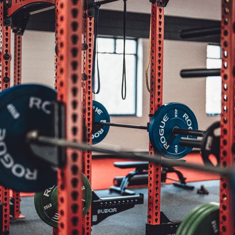 Close-up view of gym equipment with barbells and weight plates, perfect for strength training enthusiasts.