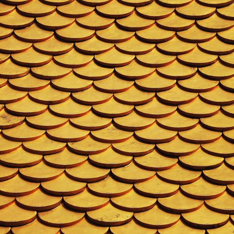 Close-up of a golden scaled roof pattern, ideal for design backgrounds or wallpapers.