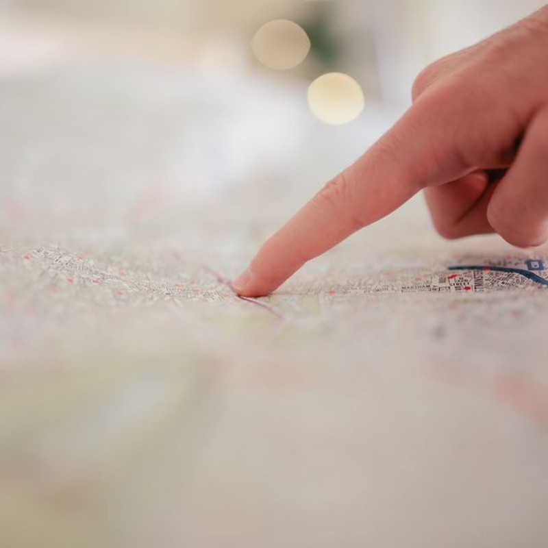 A hand pointing at a city map, highlighting direction and navigation planning.