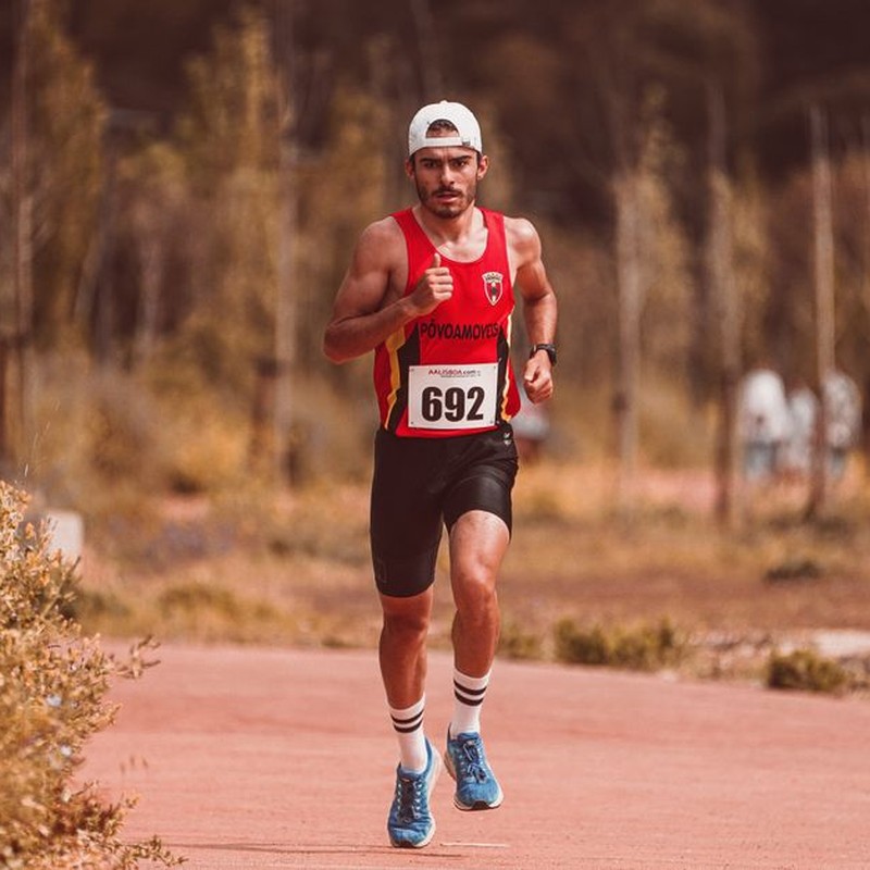 Athletic male runner participating in an outdoor marathon race on a sunny day.