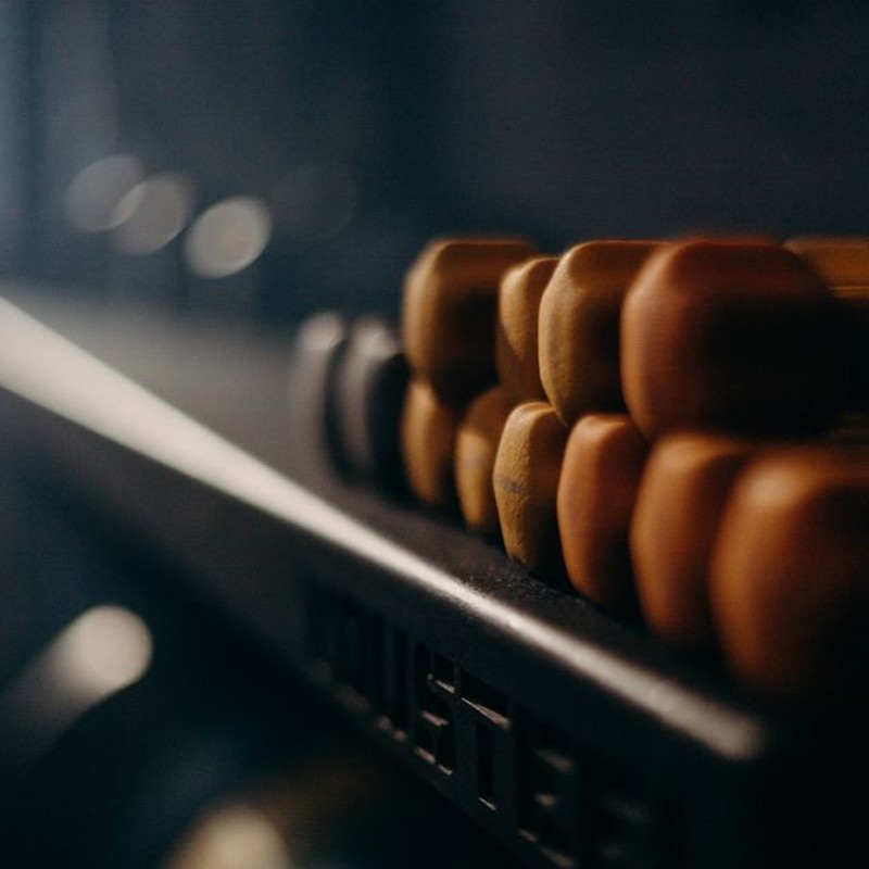A rack of dumbbells in a dimly lit gym, highlighting fitness equipment.