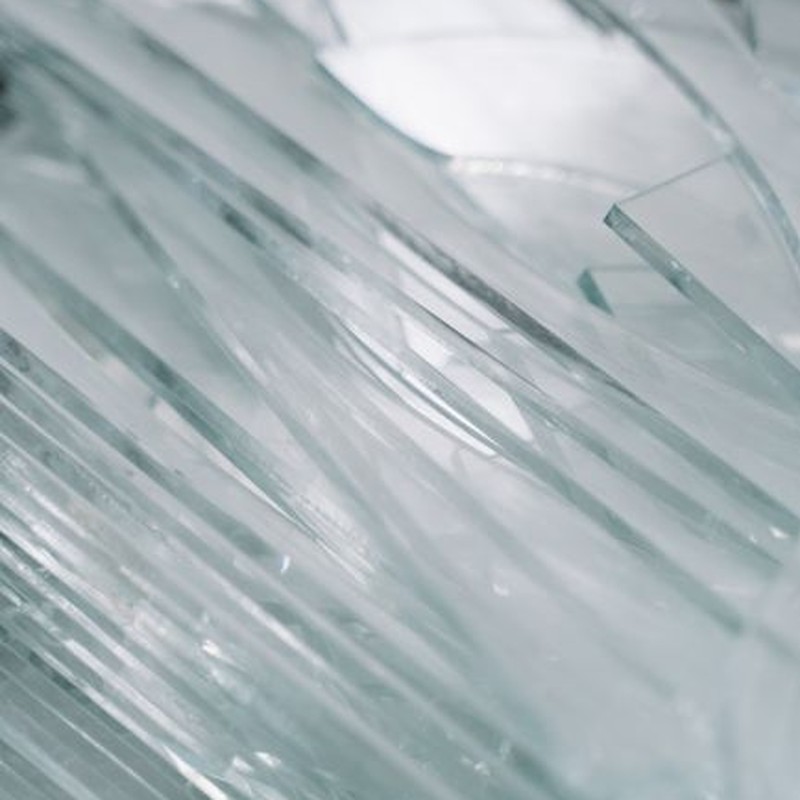 Detailed view of sharp glass pieces arranged in a pile, showcasing shattered textures.