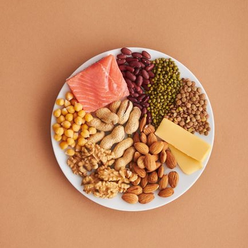 Colorful assortment of proteins and legumes on a white plate, perfect for healthy eating inspiration.