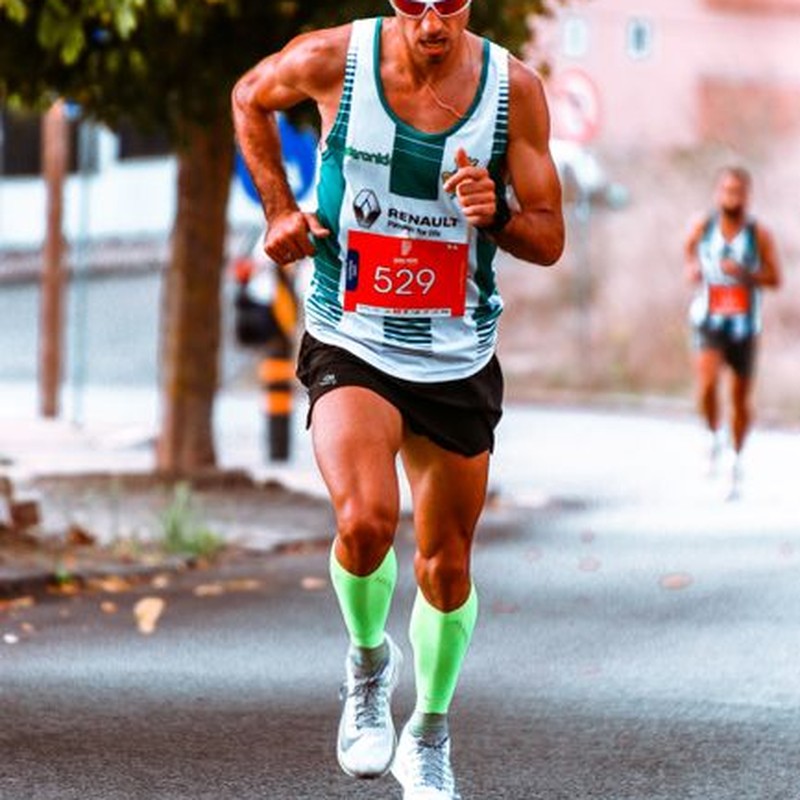 Male athlete competing in a street marathon, showcasing endurance and determination.
