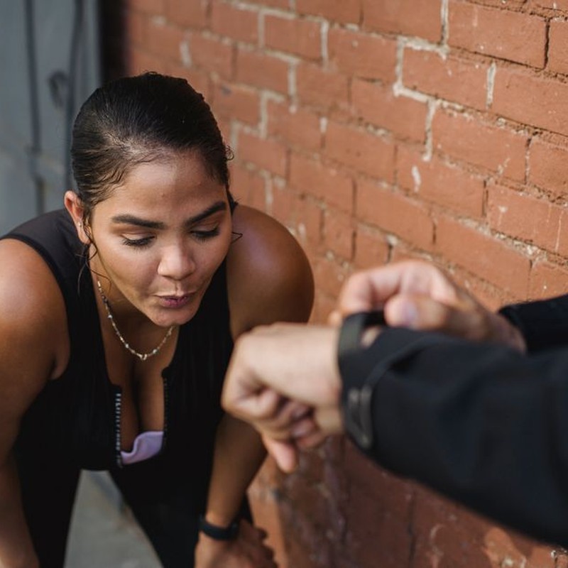 Woman in sportswear catching breath after intense exercise outdoors.